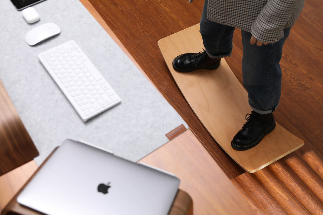 person standing on balance board behind desk